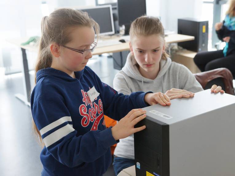 Zwei Mädchen bauen die Seitenwand an einem Desktop-Rechner an