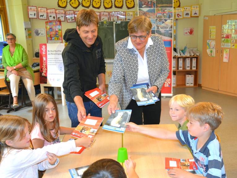 Sabine Tegtmeyer-Dette und Ralf Strobach verteilen die Hefte an die Klasse 2a der Grundschule Suthwiesenstraße