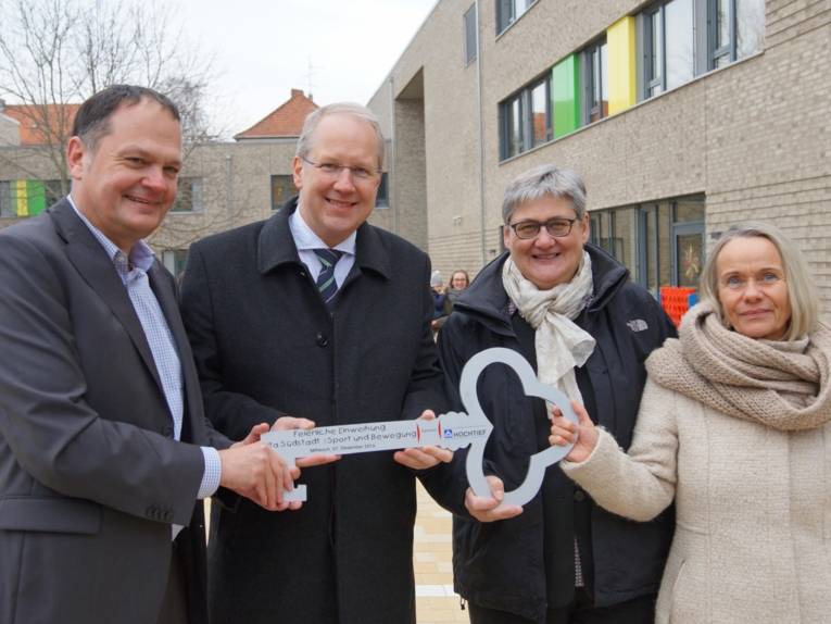 Zwei Männer und zwei Frauen mit einem großen Schlüssel. 