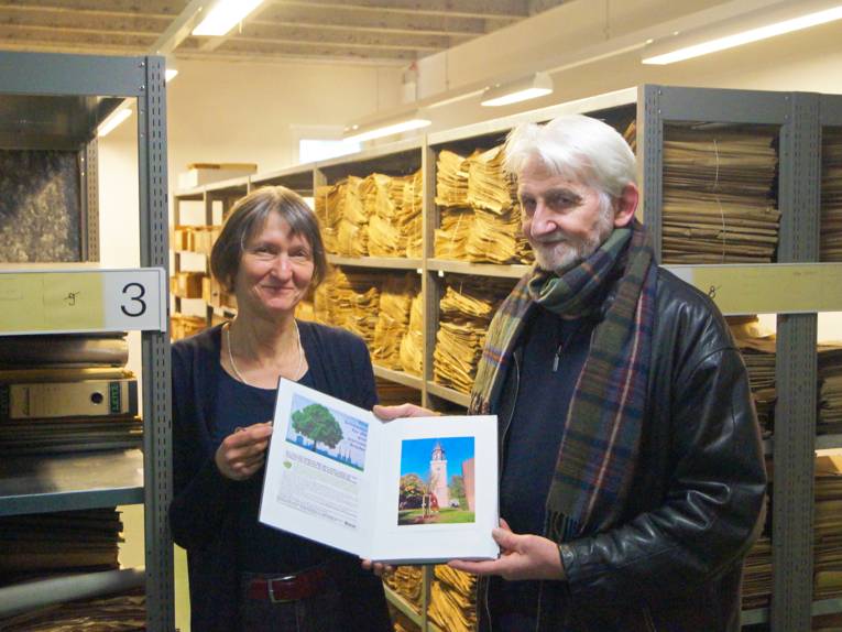 Dr. Cornelia Regin nimmt von Gerd Wach das Pflanzbuch der gespendeten Linde entgegen
