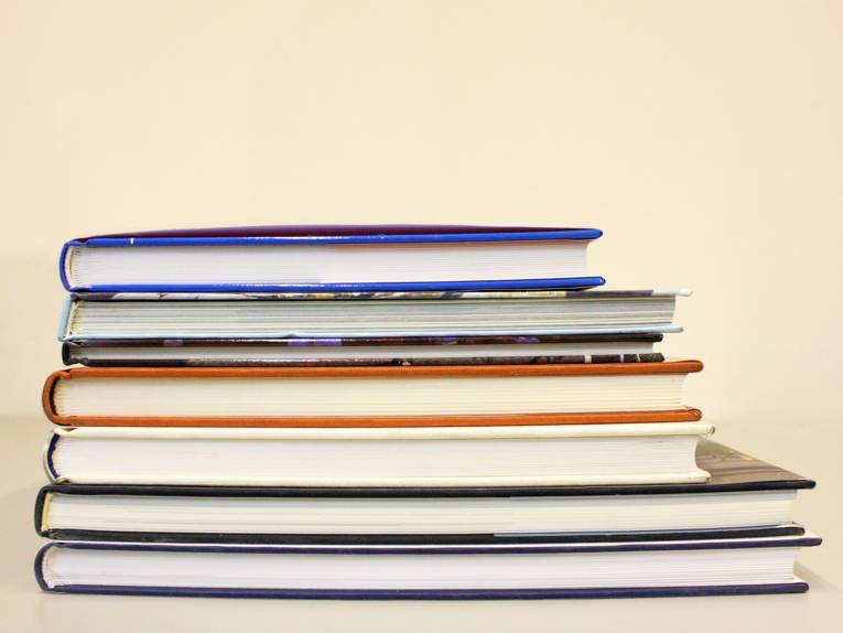 Ein Stapel aus sieben Büchern auf einem Tisch
