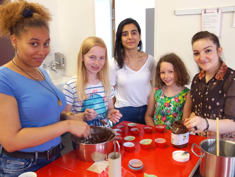Fünf Mädchen bzw. junge Frauen beim Kochen