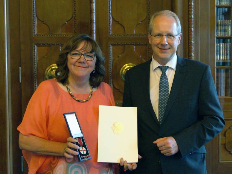 Marion Dix mit der verliehenen Medaille und Urkunde neben Oberbürgermeister Stefan Schostok