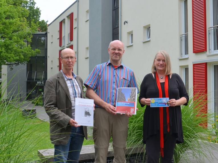Gerd Nord, Dirk Hufnagel und Karin van Schwartzenberg vor einem Passivhaus der Franz-Kühnemann-Stiftung, auf dem eine Solaranlage montiert ist