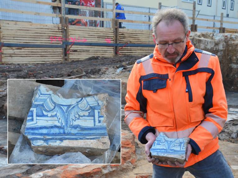 Grabungsleiter Bernhard Thiemann präsentiert das gefundene Stück eines Fayence-Kachelofens