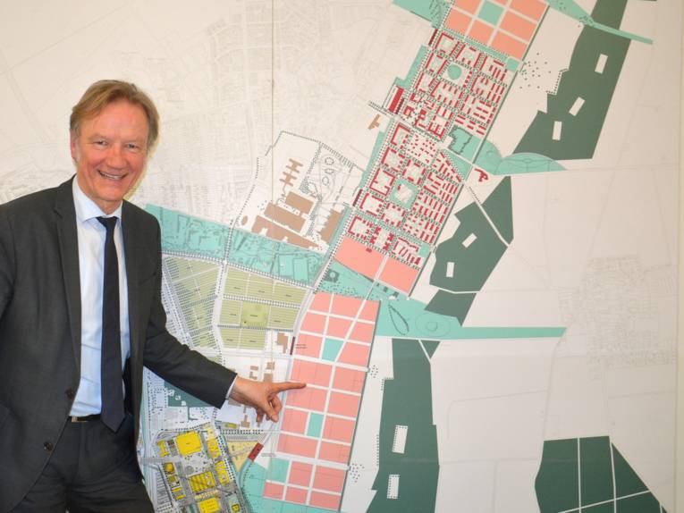Stadtbaurat Uwe Bodemann zeigt auf einer Karte das geplante Neubaugebiet Kronsberg-Süd