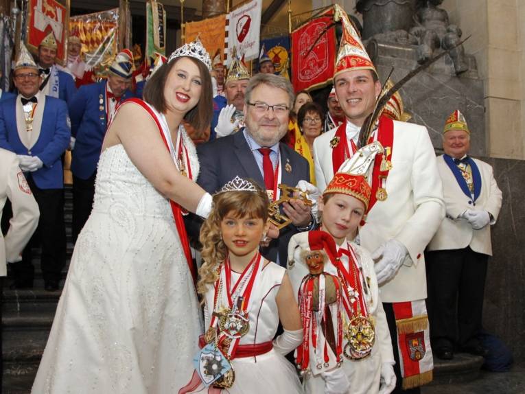 Bunt gekleidete Menschen in einer Halle. 