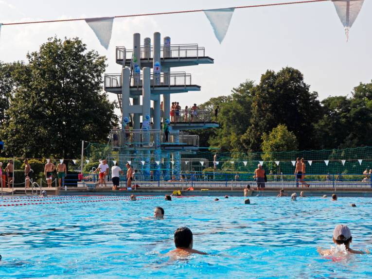 Schwimmbecken, im Hintergrund ein Sprungturm. 