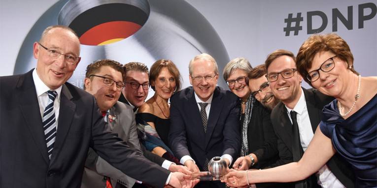 Gruppenbild der Hannoverschen Delegation in festlicher Garderobe mit dem gewonnenen Deutschen Nachhaltigkeitspreis in der Mitte