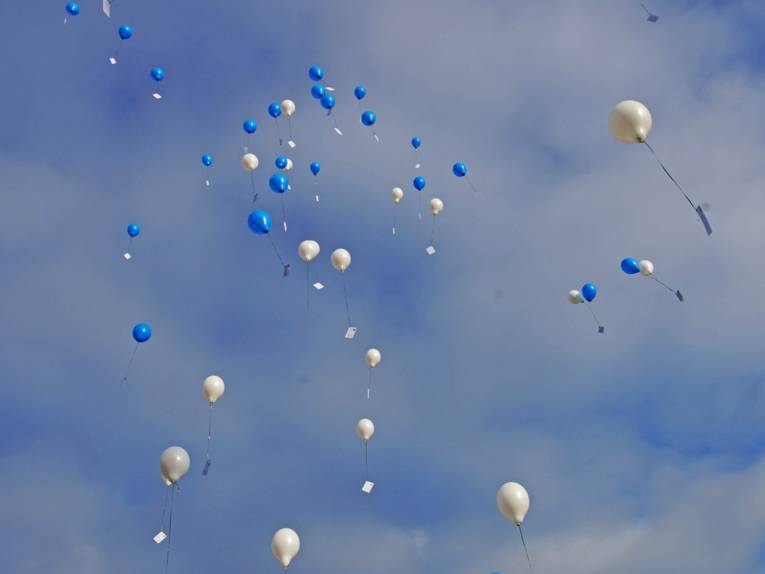Fliegende Luftballons in blau und weiß. 