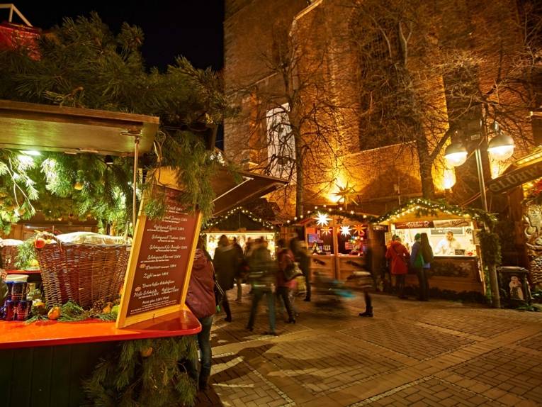 Geschmückte Stände auf einem Weihnachtsmarkt. 