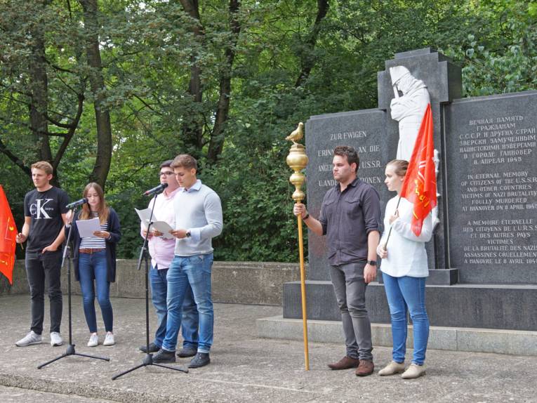 Jugendliche die vor dem Denkmal am Ehrenfriedhof eine Rede halten. 