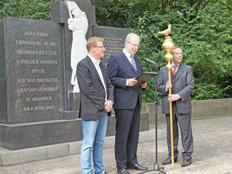 Die Übergabe der Friedenstaube durch Richard Hillinger an die Stadt Hannover, vertreten durch den Oberbürgermeister Stefan Schostok. (von links: Dirk Schulze (Erster Bevollmächtigter der IG Metall Hannver), Stefan Schostok (Oberbürgermeister der LHH), Richard Hillinger (Künstler und Schaffer der goldenen Friedenstauben) 
