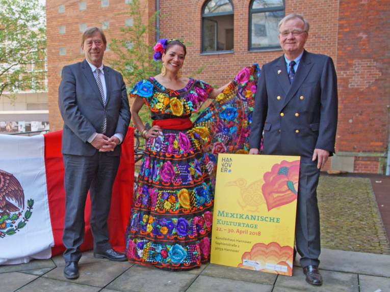 Zwei Männer und eine Frau mit einem Plakat. 
