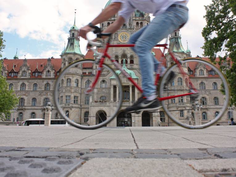 Radfahrer vor einem Rathaus.