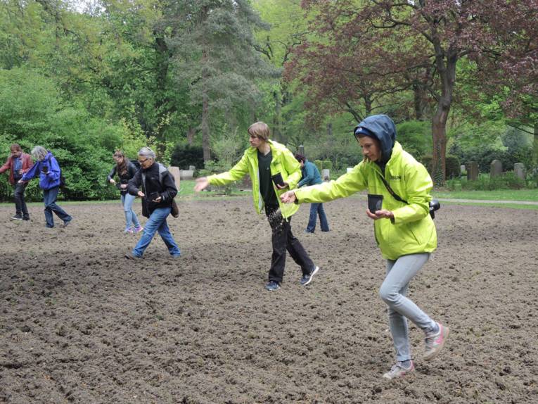 Menschen, die Samen auf ein Feld auswerfen. 