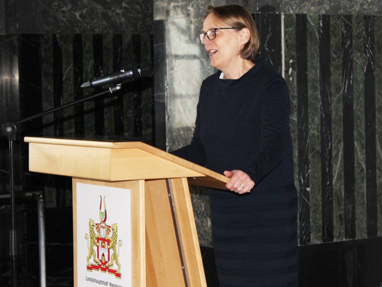 Frau an einem Rednerpult. 