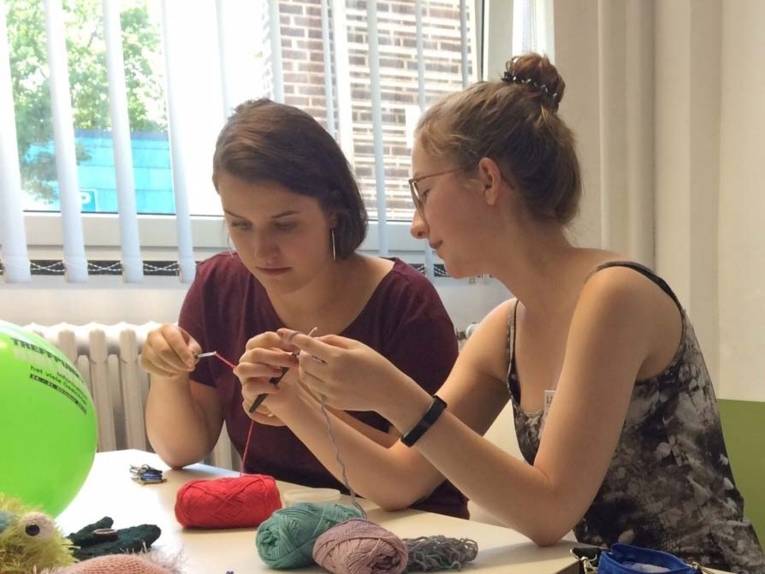 Zwei junge Frauen, die mit Wolle arbeiten. 