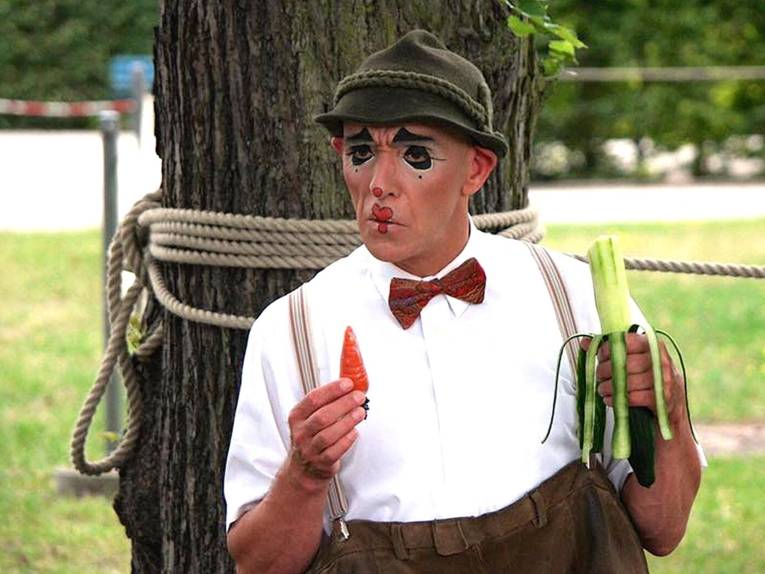 Clown vor einem Baum. 