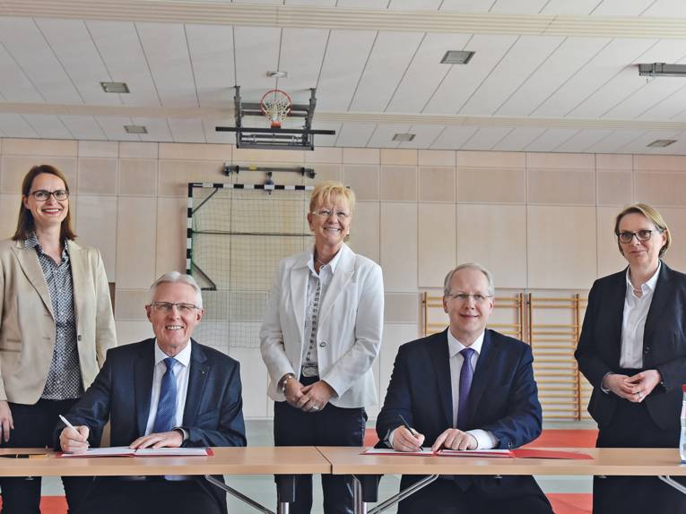 Zwei Männer und drei Frauen an einem Tisch. 