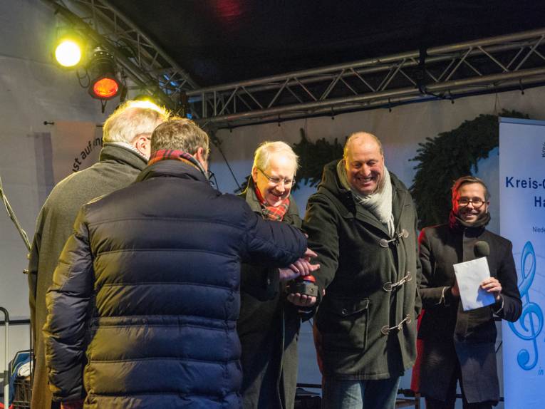 Fünf Männer an einem roten Knopf auf einer Bühne. 