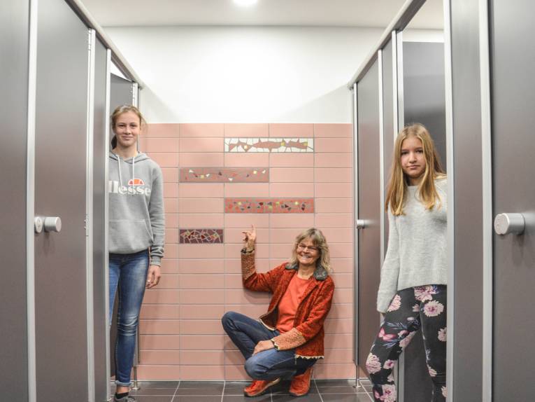 Die Künstlerin Susanne Siegl präsentiert mit zwei Schülerinnen die gemeinsam entworfenen Wandmosaike
