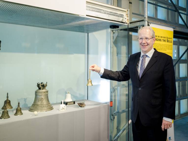 Mann mit einer Glocke.