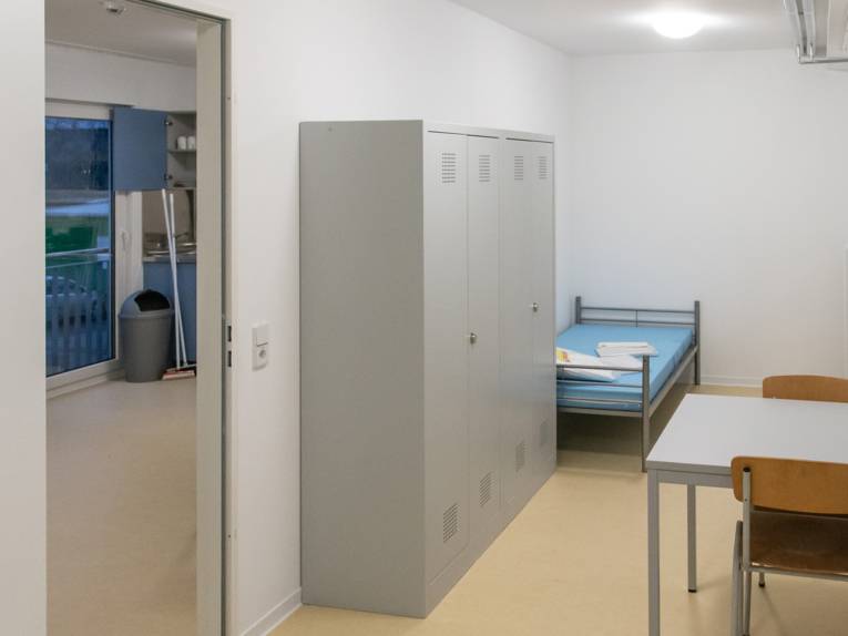 Ein Rau mit einem Bett, einem Schrank, einem Tisch