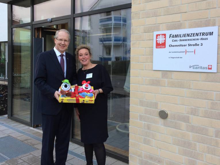 Ein Mann und eine Frau vor einem Gebäude. 