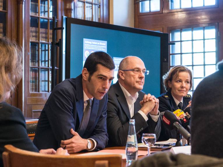 Drei Personen an einem Tisch.