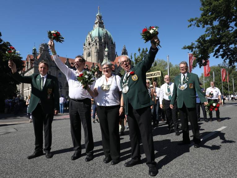 Personen auf einer Straße, im Hintergrund das Neue Rathaus