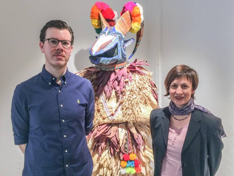 Ein Mann und eine Frau vor einer Skulptur. 