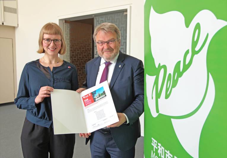 Eine Frau und ein Mann mit einer Mappe. 