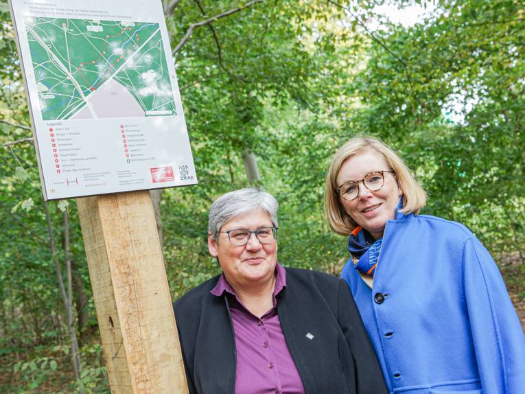 Zwei Frauen an einem Hinweisschild für einen Trimm-dich-Pfad