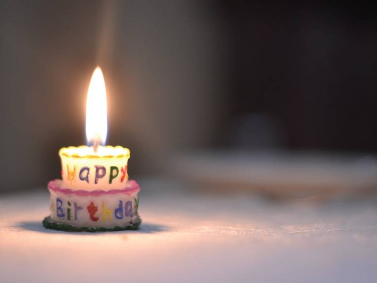 Kerze in Form einer Geburtstagstorte. 