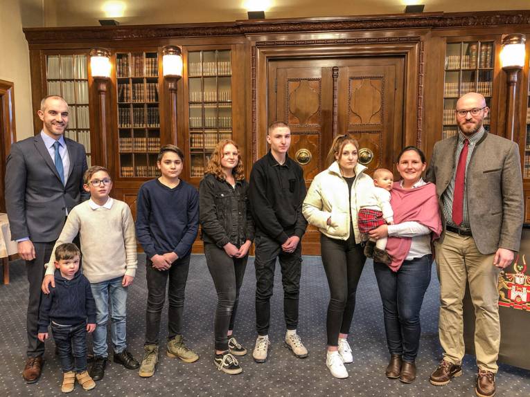 Siebenköpfige Familie mit dem Oberbürgermeister in einem Raum. 