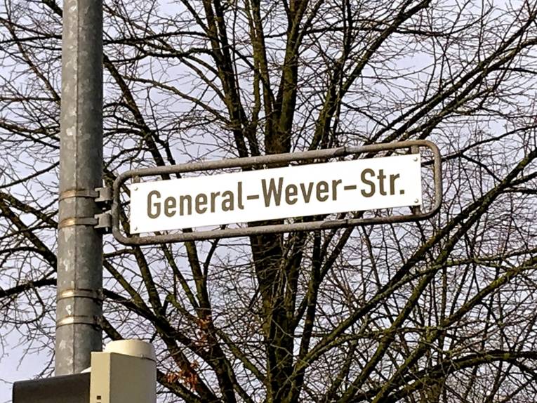 Straßenschild vor Bäumen. 