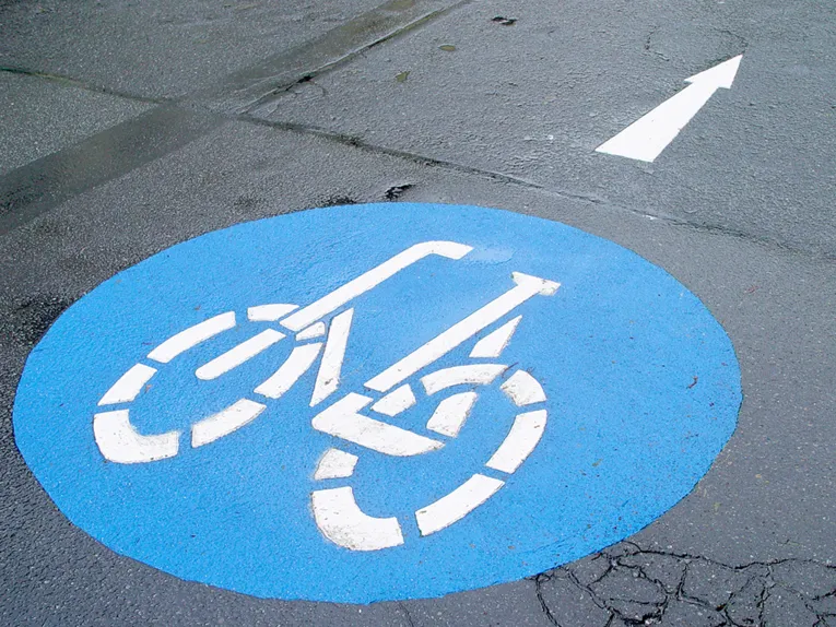 Ein weißer Strichmännchen-Radfahrer auf blauem Grund