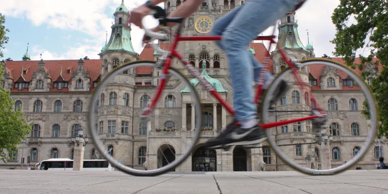 Ein Radfahrer fährt am Neuen Rathaus vorbei