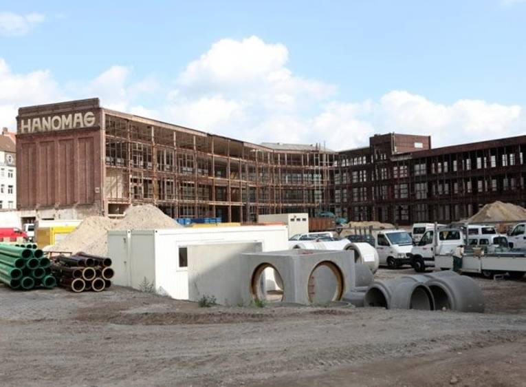 Baustellenmaterial vor entkerntem Hanomag-Gebäude