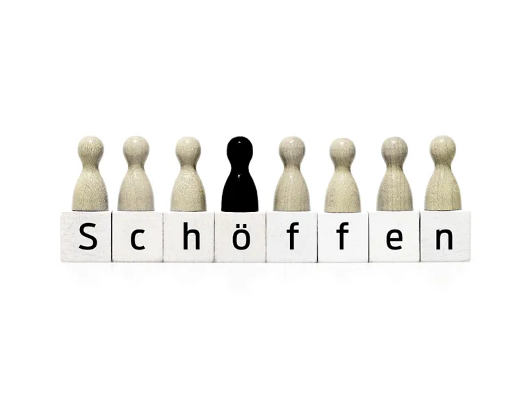 Weiße Mensch-Ärger-Dich-Nicht-Spielfiguren symbolisieren die Jugenschöffinnen und -schöffen, die schwarze Figur steht für die Richterin bzw. den Richter