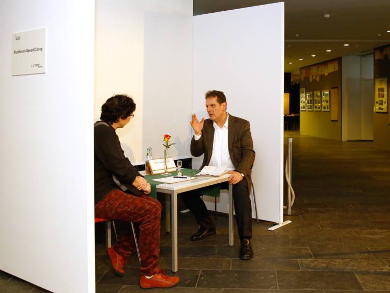 Eine Besucherin befragt den Museumsdirektor beim Kuratoren-Speed-Dating