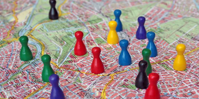 Verschiedenfarbige Spielfiguren stehen auf dem Stadtplan von Hannover.