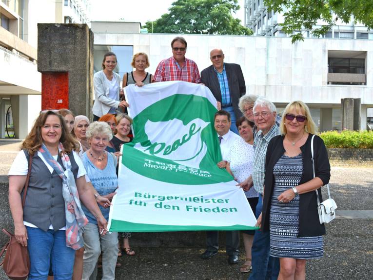 Bürgermeister Werner Arndt (Stadt Marl) hisste mit Vertretern der Ratsfraktionen, Verwaltungsbeschäftigten und Interessierten die Flagge auf dem Creiler Platz.