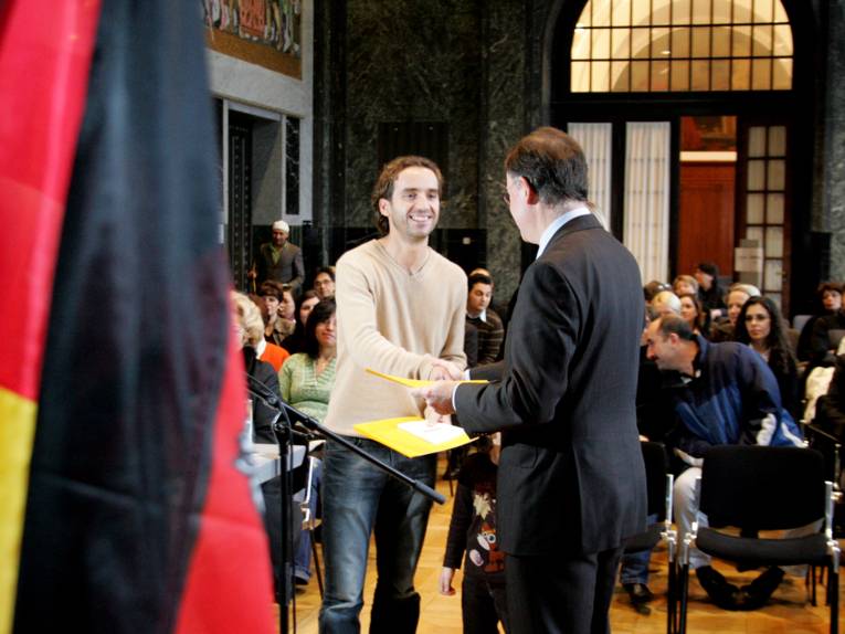 Oberbürgermeister Weil verleiht eine Einbürgerungsurkunde