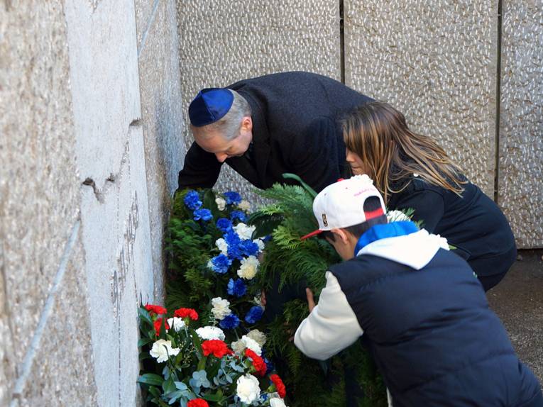 Zwei Jugendliche und Stefan Schostok legen einen Kranz am Gedenkort der zerstörten Synagoge nieder
