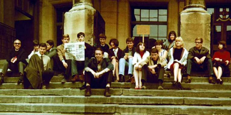 Eine Gruppe Jugendlicher auf den Stufen vor einem Gebäude sitzend