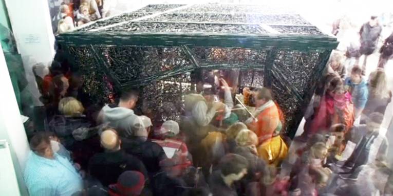 Menschen, die verschwommen aufgenommen sind, agieren mit einer Kunstinstallation