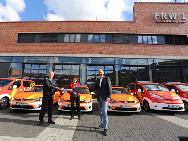 Personen stehen vor Fahrzeugen der Feuerwehr Hannover