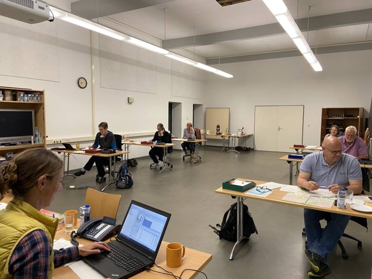 Verschiedene Menschen sitzen in einem Raum